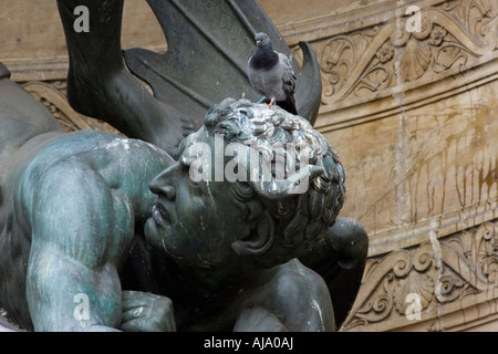 Un pigeon qui perturbe l'une des statues de la Fontaine Saint Michel à Paris Banque D'Images