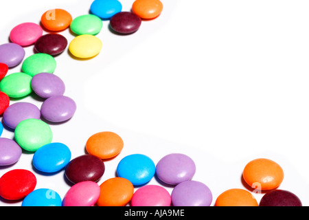 Bonbons colorés disposés dans un modèle sur un fond blanc avec copie espace Banque D'Images