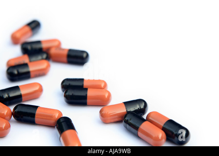 Capsules en noir et orange sur fond blanc Banque D'Images
