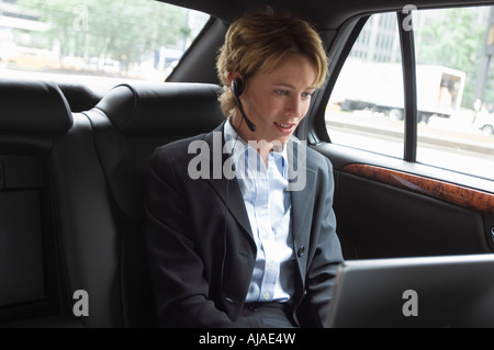 Businesswoman Using Laptop in Car Banque D'Images