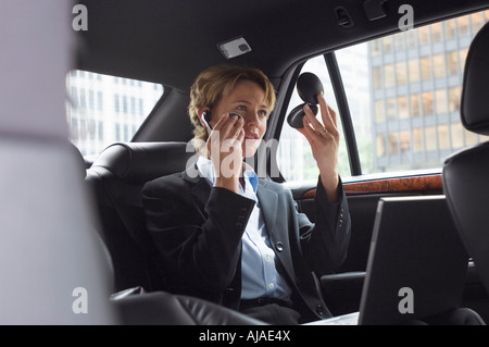 Woman Applying Make-Up in Back Seat of Car Banque D'Images