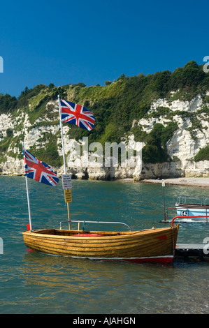 Le bateau avec deux drapeaux Union Jack survolant sur la plage de bière Devon England UK Banque D'Images