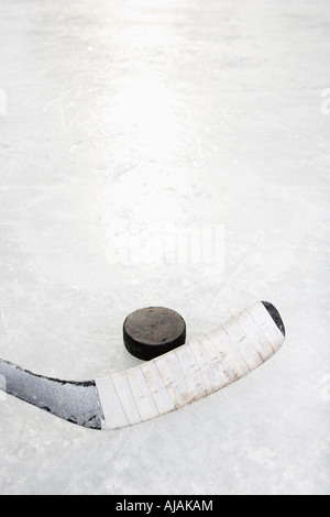 A proximité de la glace en bâton de hockey sur glace en position de frapper rondelle de hockey Banque D'Images