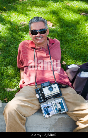 Un photographe avec son appareil Polaroïd Macarthur Park Los Angeles California USA Banque D'Images