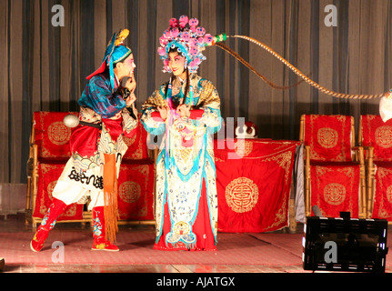 Deux jeunes et talentueuses actrices de l'Opéra de Chengdu habillés en vêtements traditionnels d'effectuer sur la scène. Banque D'Images