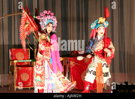 Deux jeunes et talentueuses actrices de l'Opéra de Chengdu habillés en vêtements traditionnels d'effectuer sur la scène. Banque D'Images