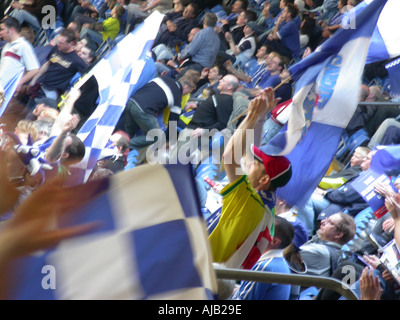 Brandir le drapeau brouillée par le football foule au stade du millénaire, Cardiff Banque D'Images