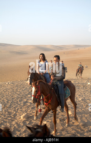 Les gens de l'équitation dans la région de Stony desert tôt le matin, ciel voilé soleil Gizeh Le Caire Egypte Afrique Banque D'Images