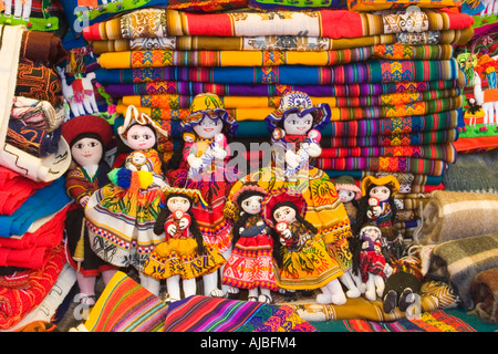 Poupées traditionnelle péruvienne et des tissus textiles en vente dans le marché de Pisac au Pérou de décrochage Banque D'Images