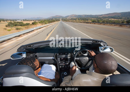 La conduite d'un homme africain sur un convertible mur de barrage - vue arrière Banque D'Images