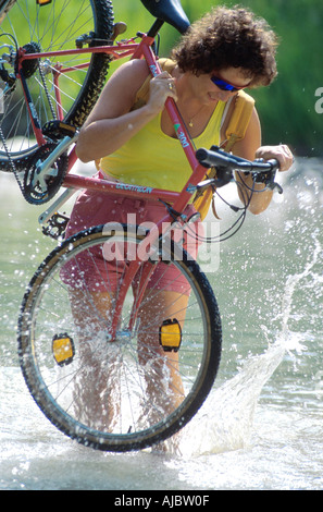 Femme crossing creek, exerçant son activité sous location Banque D'Images