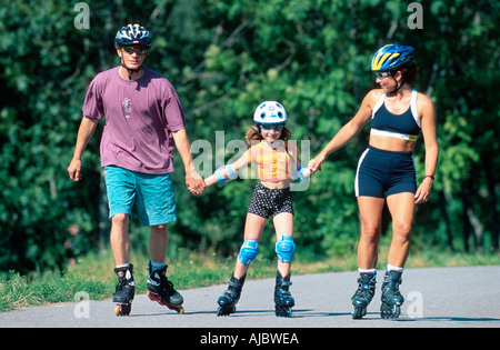 Family roller, le port du casque à vélo, se tenant la main Banque D'Images