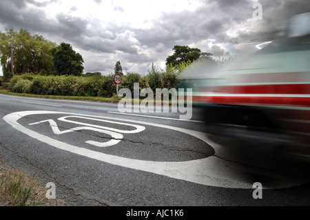 Accélération floue automobile passe 30mph vitesse limite sign painted on road Banque D'Images