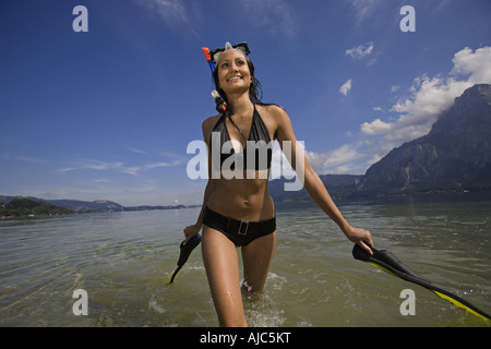 Jeune femme avec de l'eau et de l'équipement sportif à un lac, à l'Autriche, Traunsee Banque D'Images