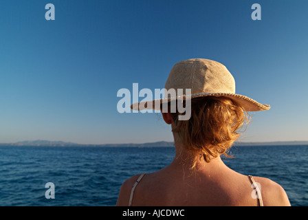 Jeune femme dans un chapeau à la recherche sur la mer Banque D'Images