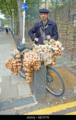 Vendeur l'oignon - l'homme de vendre les oignons et l'ail à partir de la location à l'extérieur d'Islington Farmers Market London England UK Banque D'Images