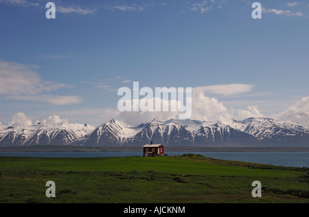 Chalet en bois sur les rives de l'Eyjafjordur avec les montagnes derrière Kaldbakur près du centre nord de l'Islande Dalvik Banque D'Images