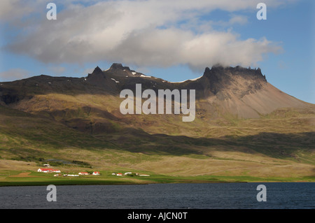 La crête dentelée de collines au-dessus d'un canton agricole sur la côte nord de Berufjordur en fjords de l'Est Région de l'Est de l'Islande Banque D'Images