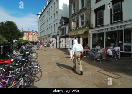 Cambridge City pavement à côté de l'église Great St Marys avec des tables et des chaises à l'extérieur de tante magasin de thé vue arrière homme marchant dans le comté de Cambridgeshire Royaume-Uni Banque D'Images