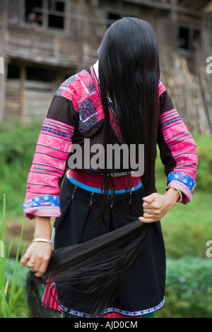 Un Yao rouge femme peignant la ses longs cheveux son village est réputé pour être dans le Guiness Book des records pour les cheveux plus longs Banque D'Images