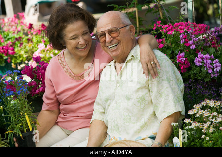 Couple parmi les fleurs à une pépinière, portrait Banque D'Images