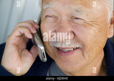 Senior man using mobile phone, (close-up) Banque D'Images