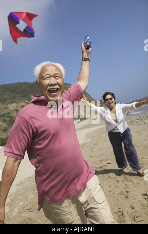 Couple flying kite on Beach Banque D'Images