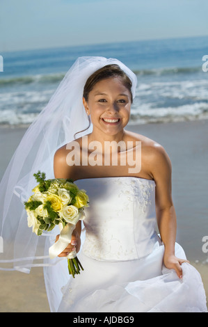 Mariée avec bouquet sur plage, smiling, (portrait) Banque D'Images