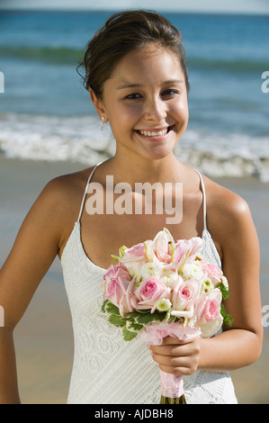 Mariée avec bouquet sur plage, smiling, (portrait) Banque D'Images