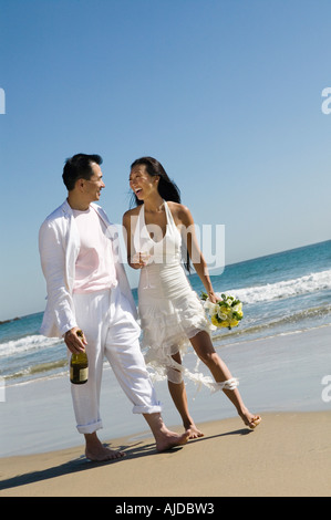 Bride and Groom walking on beach Banque D'Images