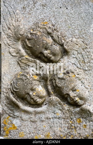 Trois angelots sculptés sur le côté d'une tombe dans le cimetière du village des Cotswolds, Gloucestershire de Ozleworth Banque D'Images