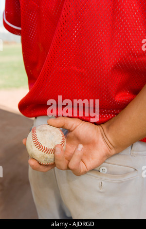 Balle de baseball holding, (close-up), (mid section) Banque D'Images