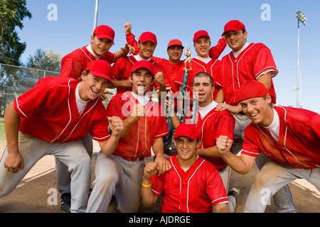 L'équipe de baseball des coéquipiers holding trophy sur terrain Banque D'Images