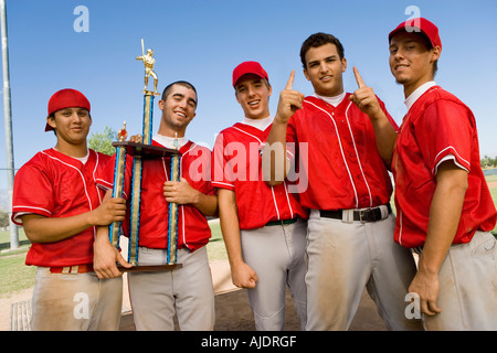 L'équipe de baseball des coéquipiers holding trophy sur terrain Banque D'Images