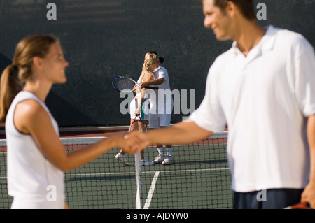 Les joueurs de tennis se serrer la main au filet, side view Banque D'Images