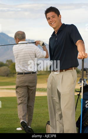 Smiling Young Man Standing on Golf Course avec homme plus âgé Banque D'Images