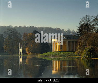 Vue sur le Temple de la musique entouré par les eaux du lac encore à West Wycombe Park Buckinghamshire Banque D'Images