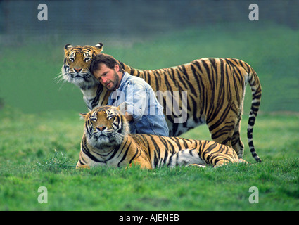 Avec gardien Le gardien des tigres a apporté les tigres de louveteaux et a développé une relation de confiance avec eux Banque D'Images