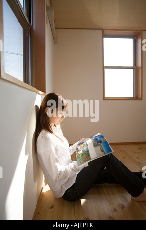Young woman reading magazine Banque D'Images
