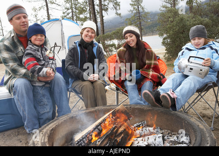 Famille avec deux enfants (7-12 ans) assis autour de camp, (portrait) Banque D'Images