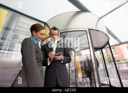 Happy businesswoman PDA en face de la porte tournante, un faible angle de vue Banque D'Images