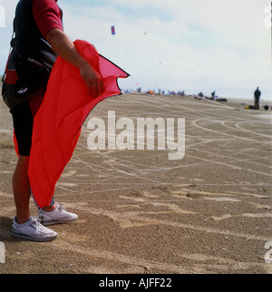 Man holding a red kite kite à Pembrey Sands buggying rassemblement sur Carmarthenshire South Wales UK KATHY DEWITT Banque D'Images