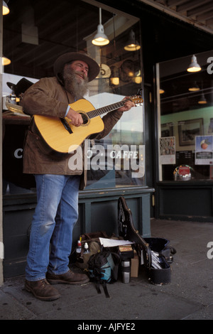 Musicien de rue avec guitare effectue l'extérieur original Starbucks Coffee Store à Pike Place Market à Seattle, Washington Banque D'Images