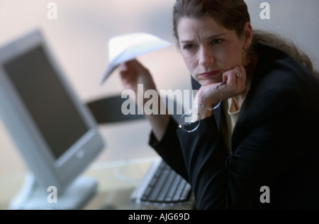Bored businesswoman holding paper plane Banque D'Images