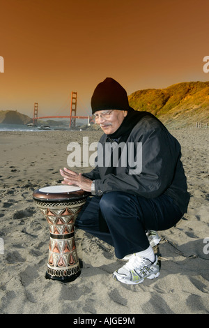 Personnes âgées indien heureusement jouant de la batterie sur baker beach turc à San Francisco, Californie Banque D'Images