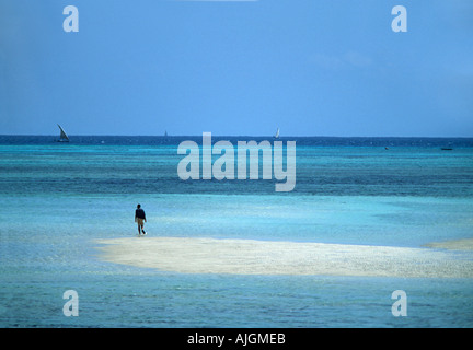 Figure solitaire marche sur un banc de sable dans des eaux turquoise Nungwi pointe nord de l'Afrique de l'Est Tanzanie Zanzibar Banque D'Images