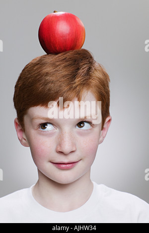 Boy balancing une pomme sur la tête Banque D'Images