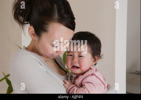 Mother holding baby crying Banque D'Images