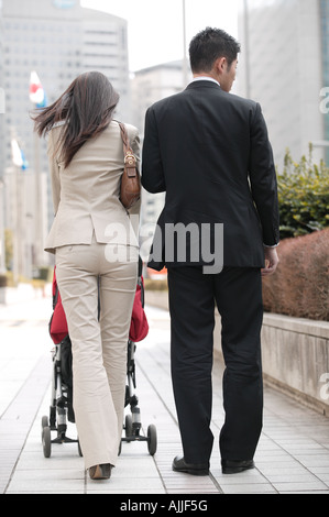 Business couple poussant poussette de bébé Banque D'Images