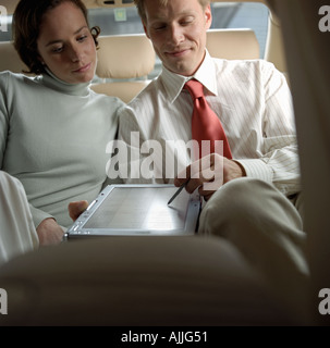 Business people using laptop in taxi Banque D'Images
